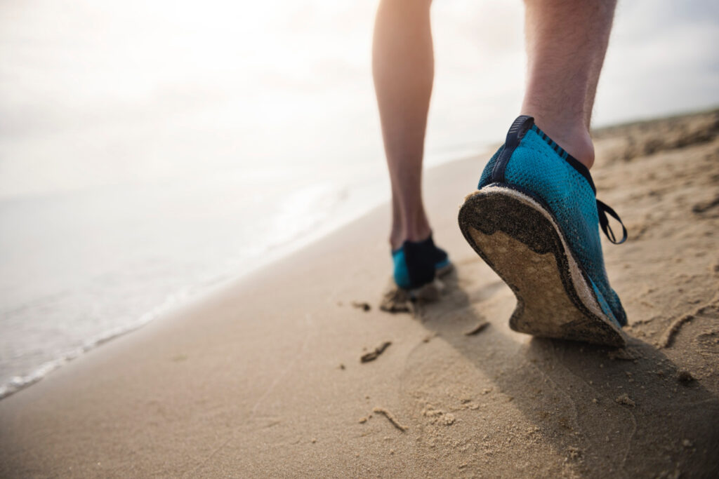 Scarpa da corsa su sabbia, simbolo di grip e supporto su superfici morbide