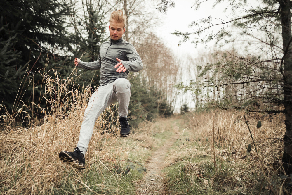 Runner che corre su terreno naturale, simbolo di un allenamento a basso impatto.