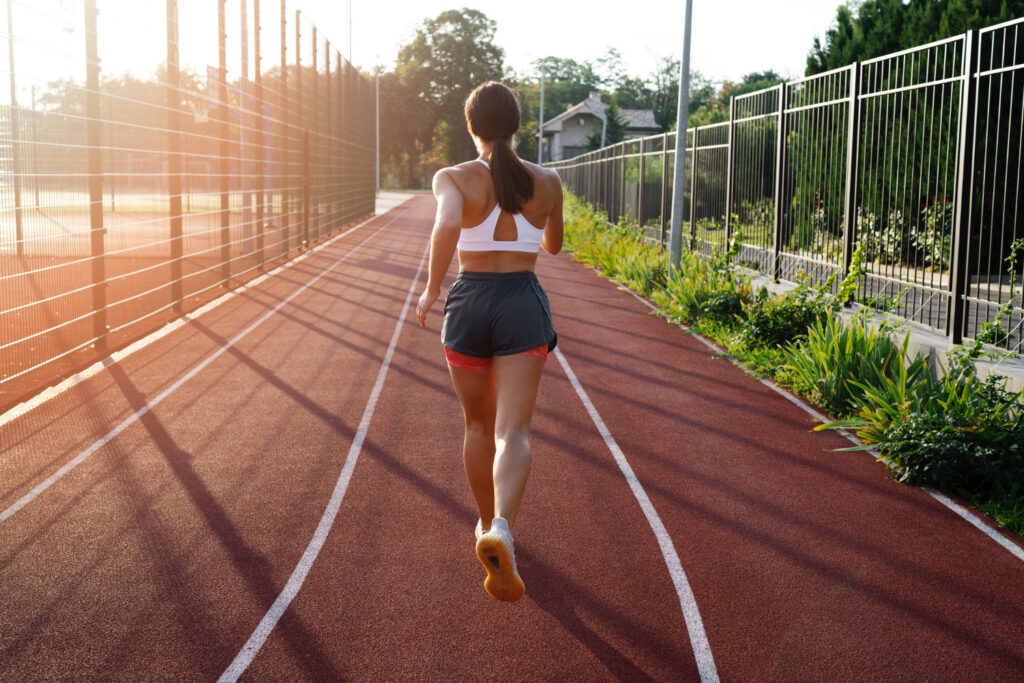 Donna che corre su una pista da atletica, rappresentando velocità e tecnica sportiva